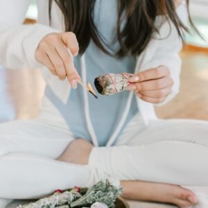 A serene scene of a woman meditating with burning sage and tarot cards.